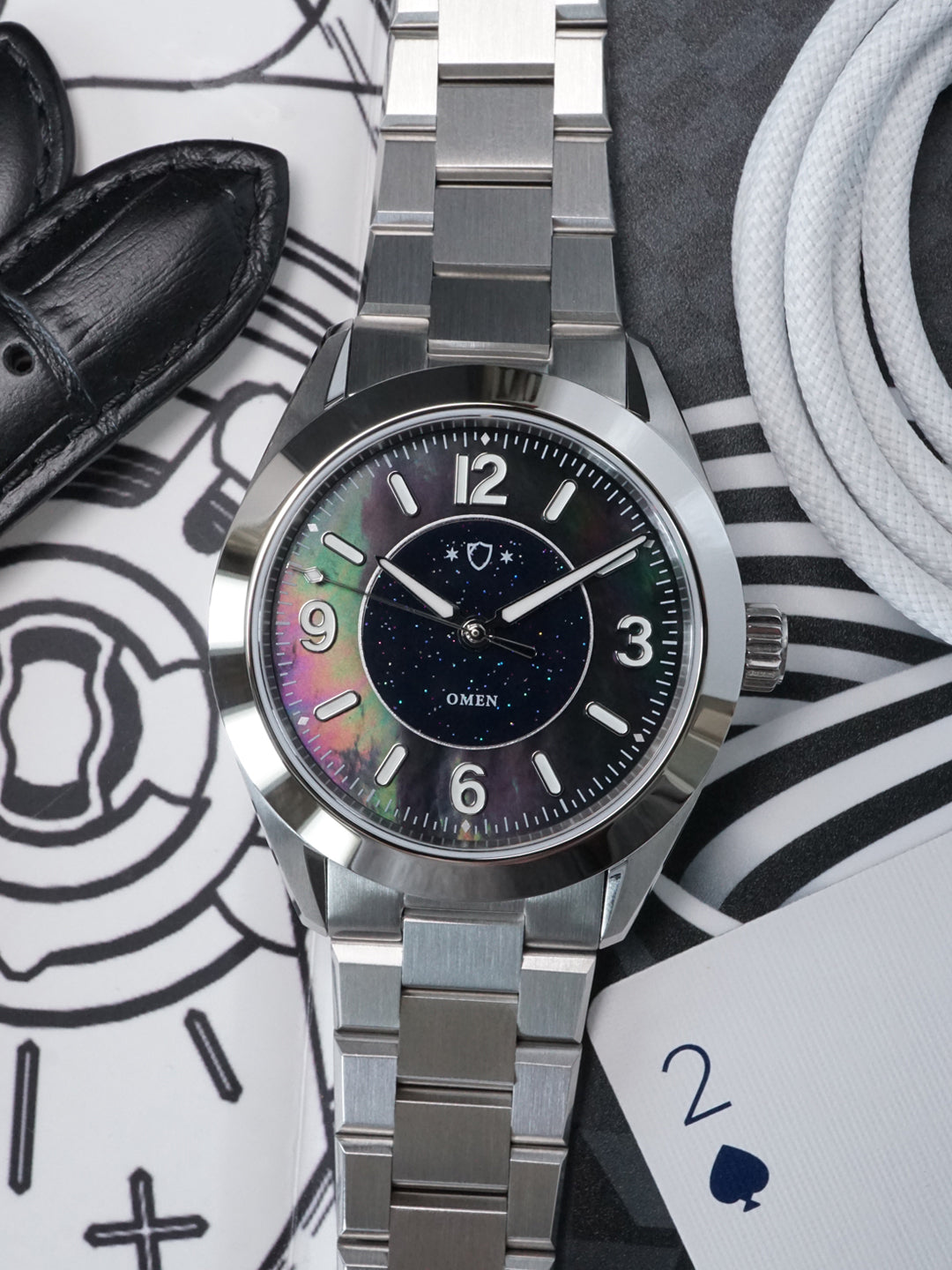Silver watch with a colorful face on a patterned surface