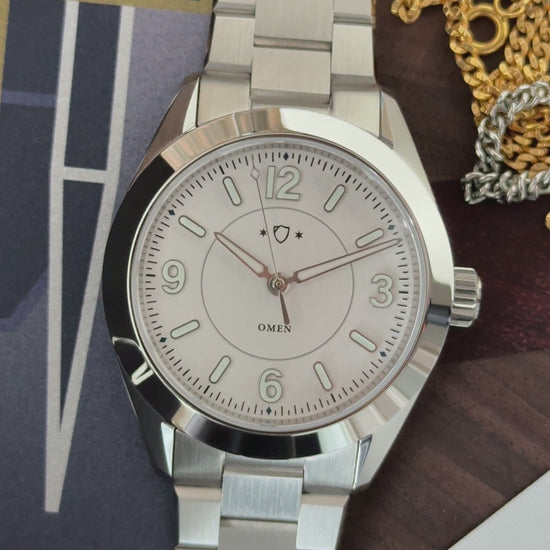 light shining across silver watch with white face.
