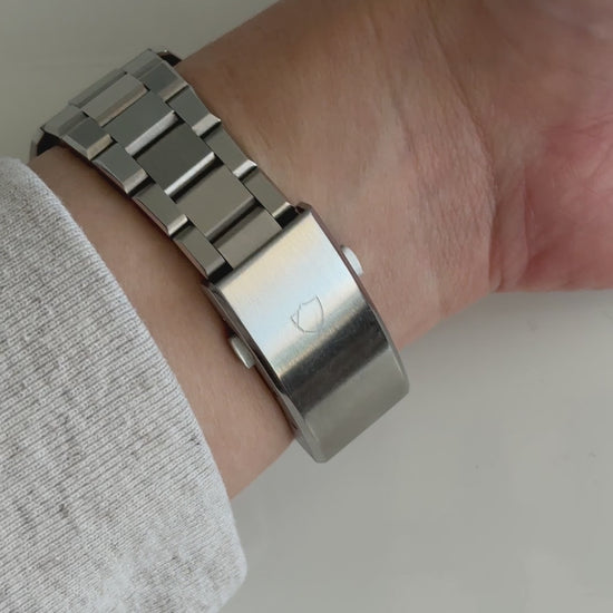 wrist roll of silver watch with white face