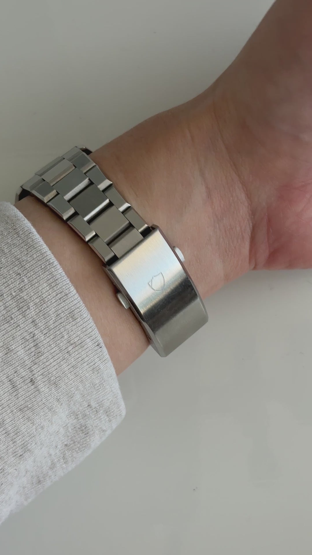 wrist roll of silver watch with white face