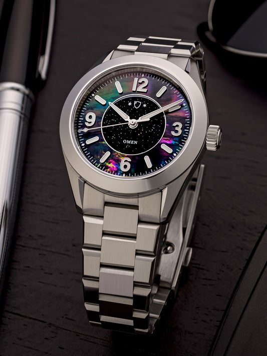 Silver watch with a colorful face on a dark surface