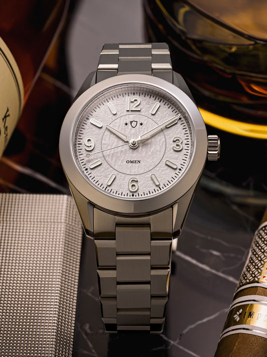 Silver watch with a detailed face on a textured surface